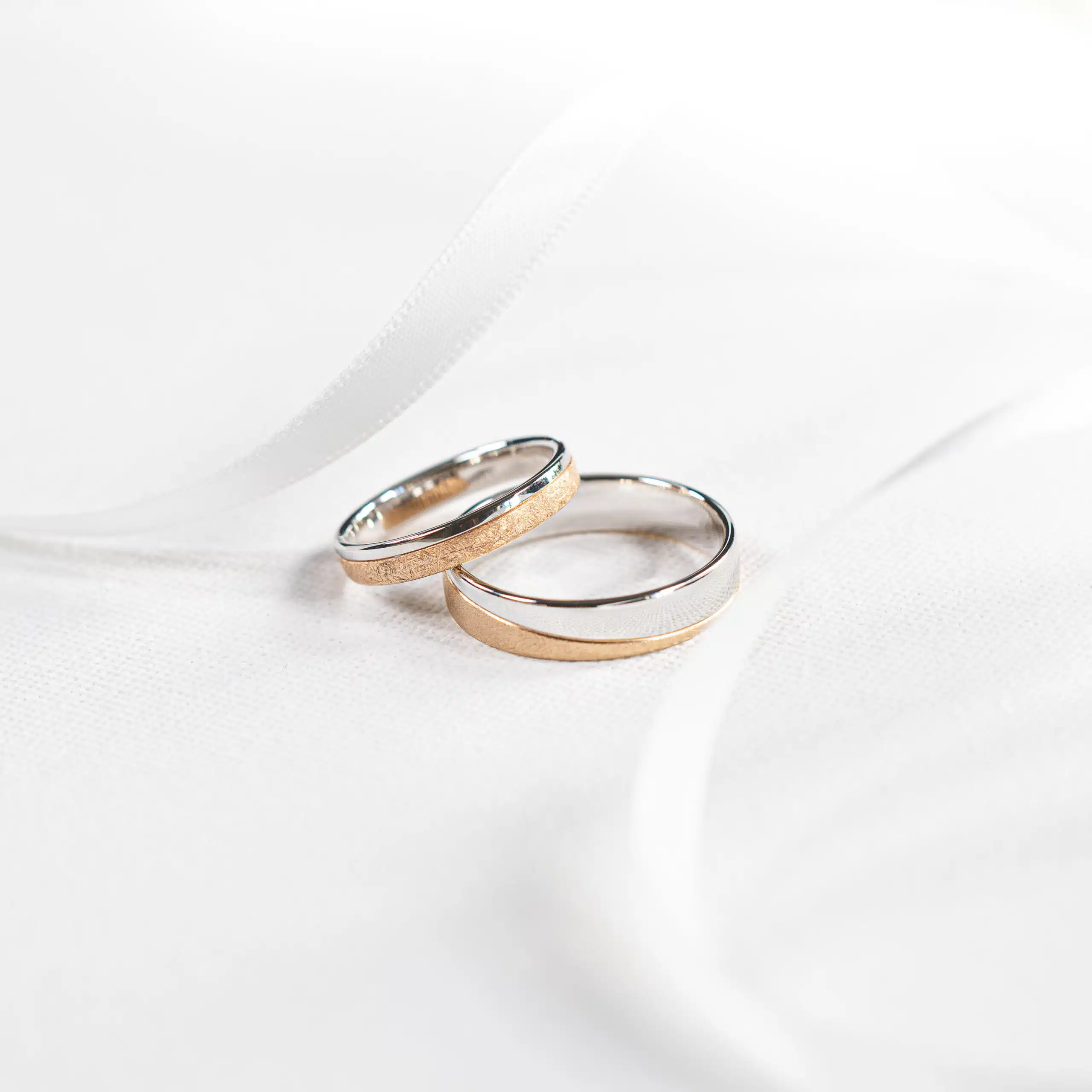 Artistic close-up of gold wedding rings with soft bokeh, symbolizing luxury and commitment.